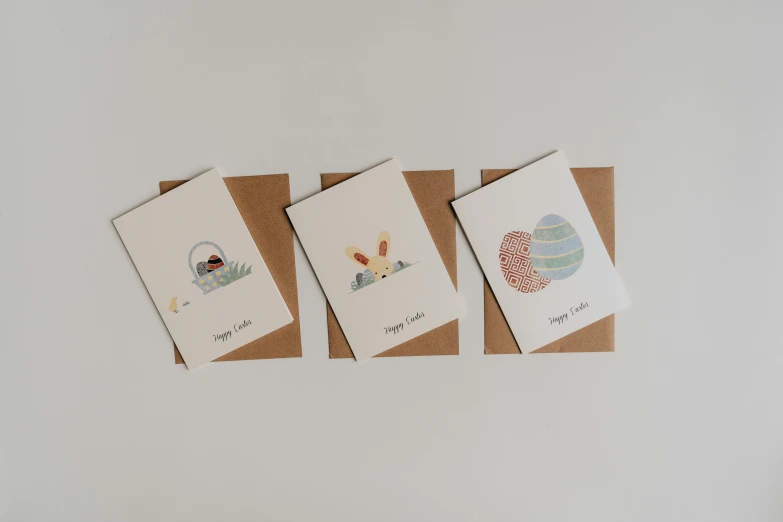 three cards with animals on them hanging on a wall, a cartoon, by Aileen Eagleton, unsplash, mingei, easter, white bg, folded, cart