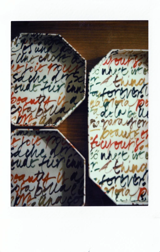 a close up of a box with writing on it, by Aileen Eagleton, instagram, papier - mache, plates, repeating pattern, six sided