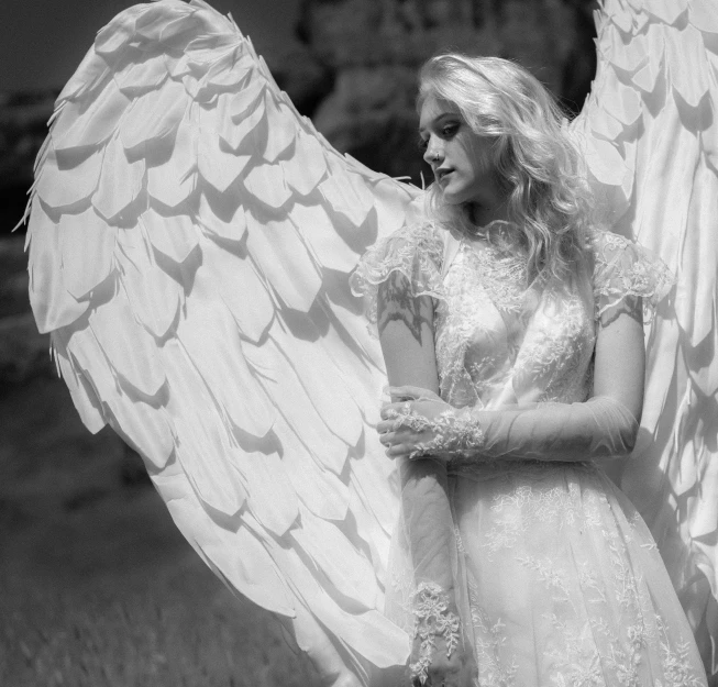 a black and white photo of a woman with angel wings, a black and white photo, by Marie Angel, pixabay contest winner, romanticism, costume design made with love, evanna lynch, wearing a wedding dress, angewomon from digimon