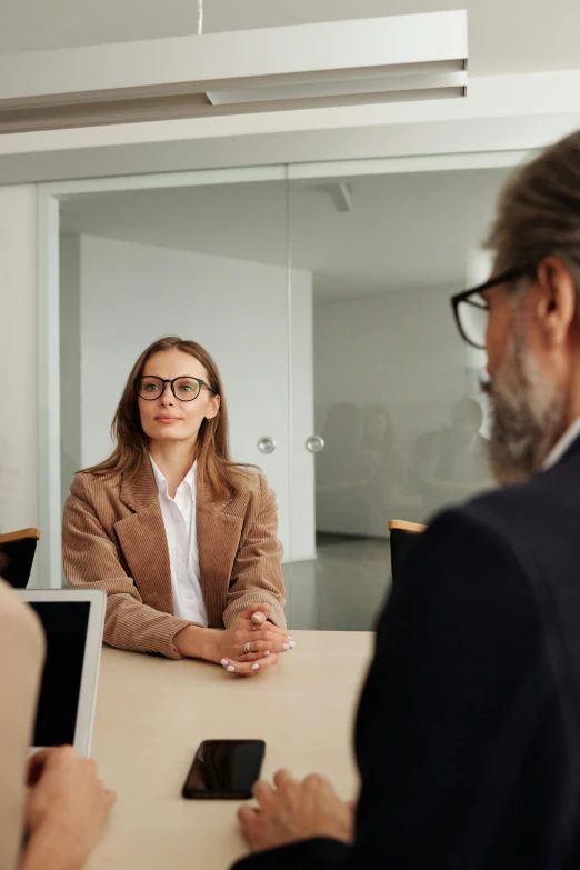 a group of people sitting around a conference table, wearing a suit and glasses, looking at each other mindlessly, high-quality photo, realistic »