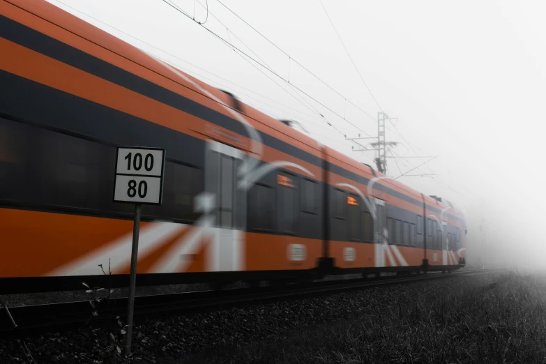 a large long train on a steel track, by Adam Marczyński, pexels contest winner, graffiti, orange fog, orange grey white, trams ) ) ), orange racing stripes