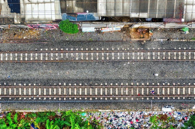 an overhead view of a train track surrounded by garbage, by Ibrahim Kodra, pexels contest winner, panoramic shot, fan favorite, where's wally, flowers around