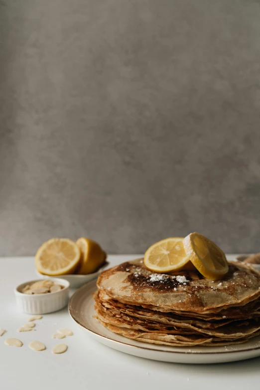 a stack of pancakes sitting on top of a white plate, by Lee Loughridge, lemons, thumbnail, humus, studio photo