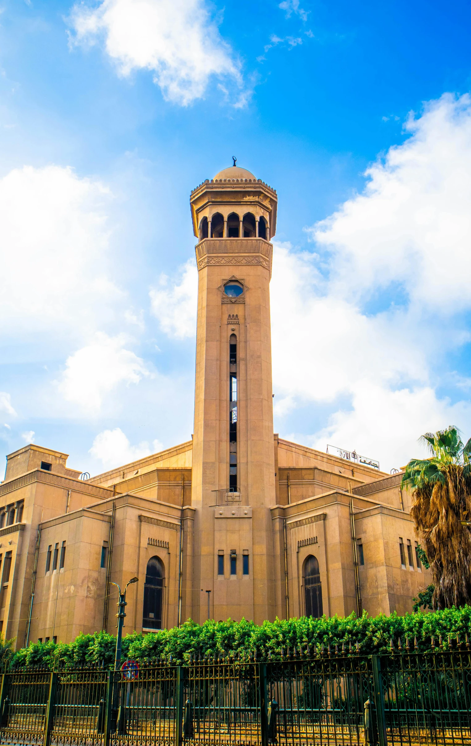 a large tan building with a clock tower, in egypt, wide angle exterior 2022, church cathedral, panoramic shot