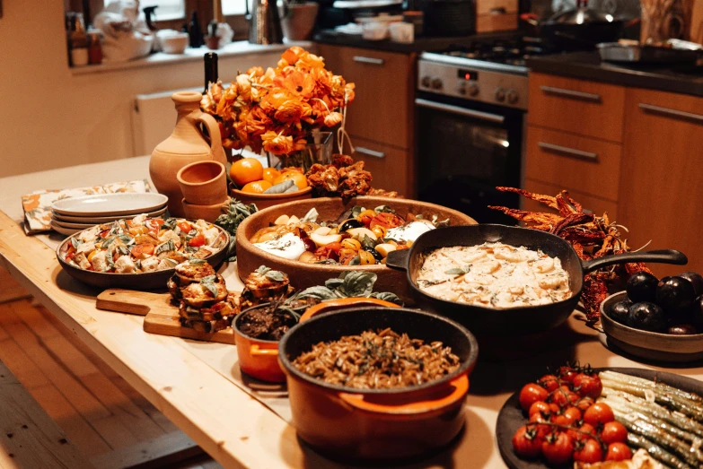 a table topped with lots of different types of food, by Carey Morris, unsplash, renaissance, black and terracotta, in the kitchen, ukrainian, warm light