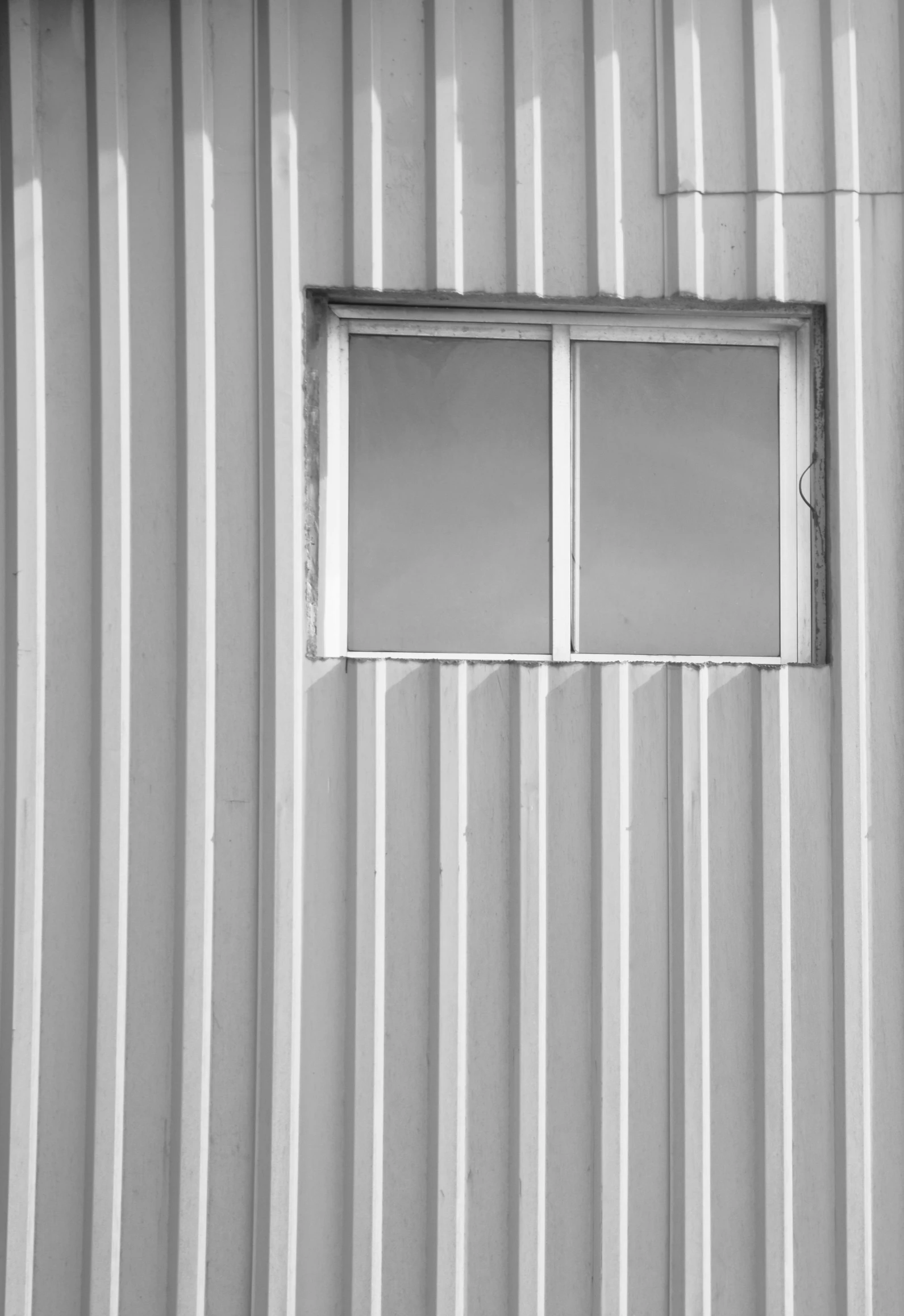 a black and white photo of a fire hydrant in front of a building, a black and white photo, inspired by Edward Weston, postminimalism, metal cladding wall, inside a shed, steel window mullions, vertical wallpaper