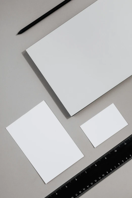 a piece of paper sitting on top of a table next to a ruler, metal panels, thumbnail, minimalistic aesthetics, white metallic