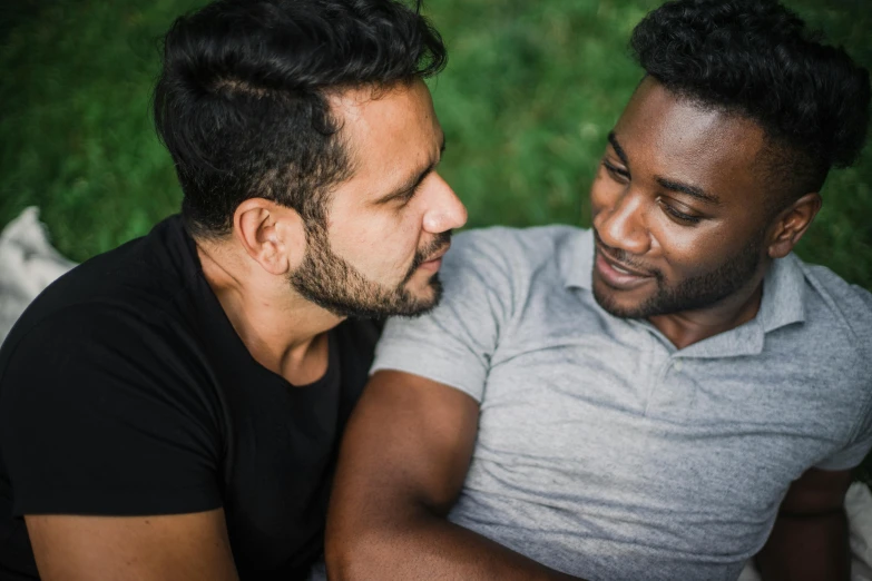 a couple of men sitting next to each other, trending on pexels, loving embrace, varying ethnicities, realistic »