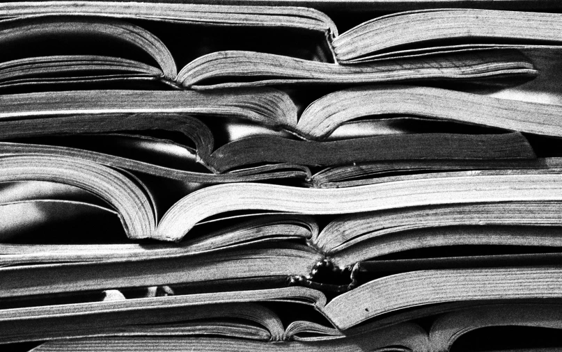 a stack of books sitting on top of each other, a black and white photo, vorticism, textbook pages, magazine pages, arcs, resources background