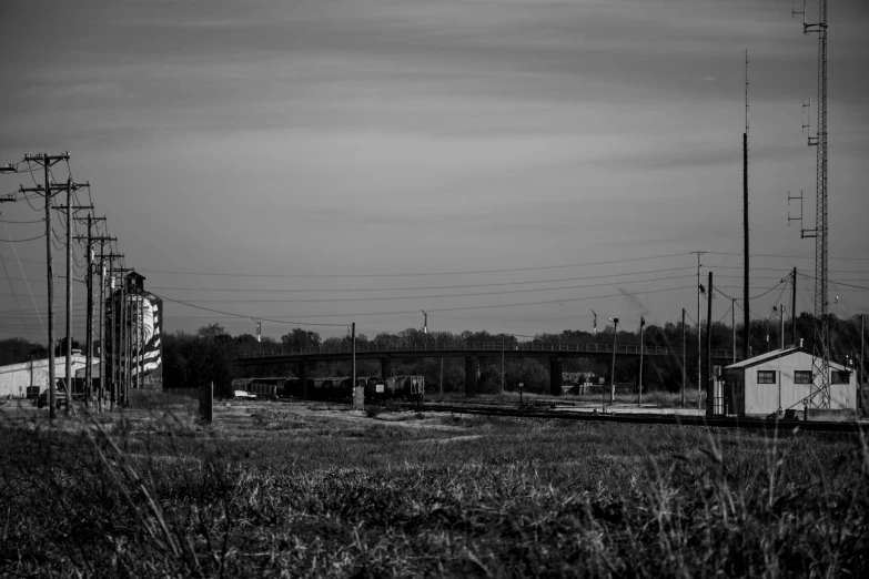 black and white pograph of an old train track near a barn