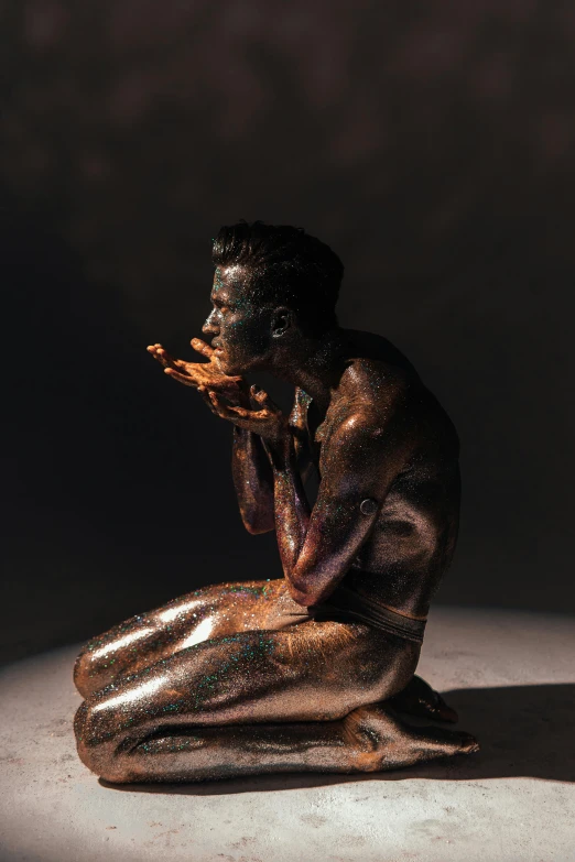 a statue of a man sitting on top of a table, a bronze sculpture, inspired by Hedi Xandt, featured on zbrush central, smothered in melted chocolate, praying with tobacco, 2019 trending photo, made of glazed