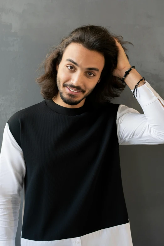 a man is smiling while wearing a black and white sweater