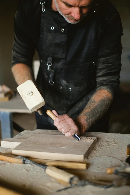 a man working on a piece of wood with a hammer, trending on pexels, arbeitsrat für kunst, 9 9 designs, rectangle, 15081959 21121991 01012000 4k, very aesthetically pleasing