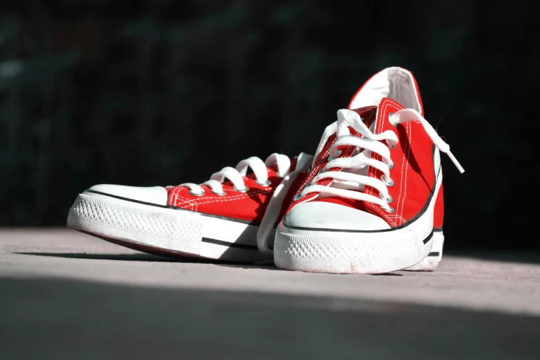 a red sneakers with white laces is seen