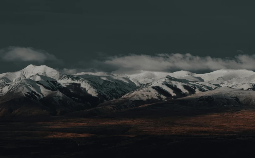 some snowy mountains under a cloudy sky