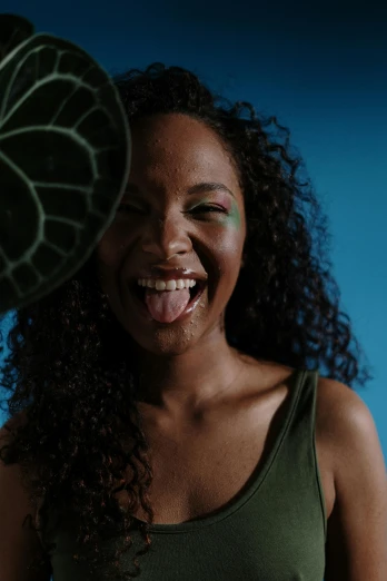 a close up of a person holding a frisbee, by Hannah Tompkins, afrofuturism, dramatic smile pose, greens), tongue out, slide show