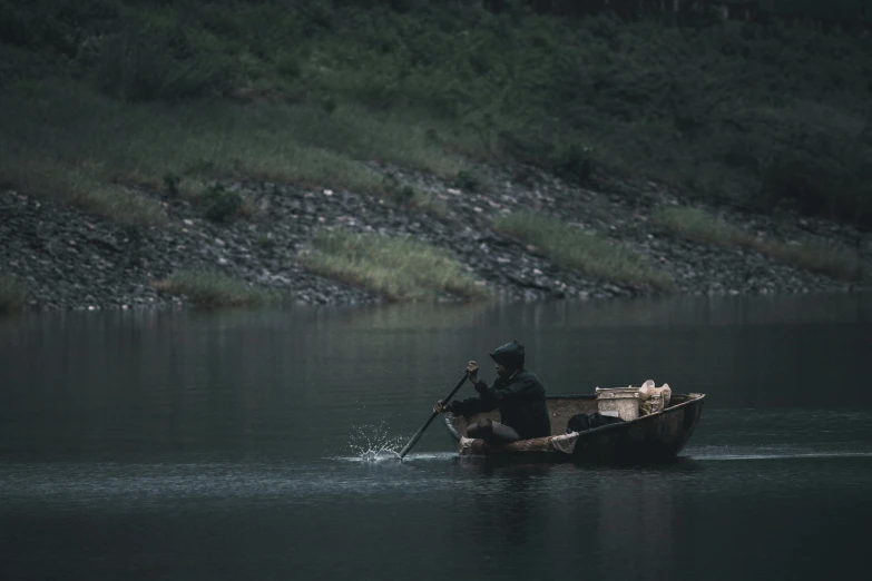 a person in a boat on a body of water, by Elsa Bleda, pexels contest winner, australian tonalism, hunting, cinematic 8k, grey, farming