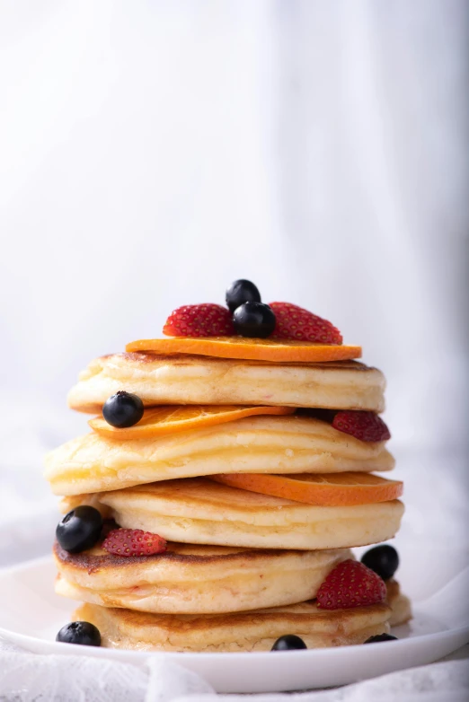 a stack of pancakes with fruit on top