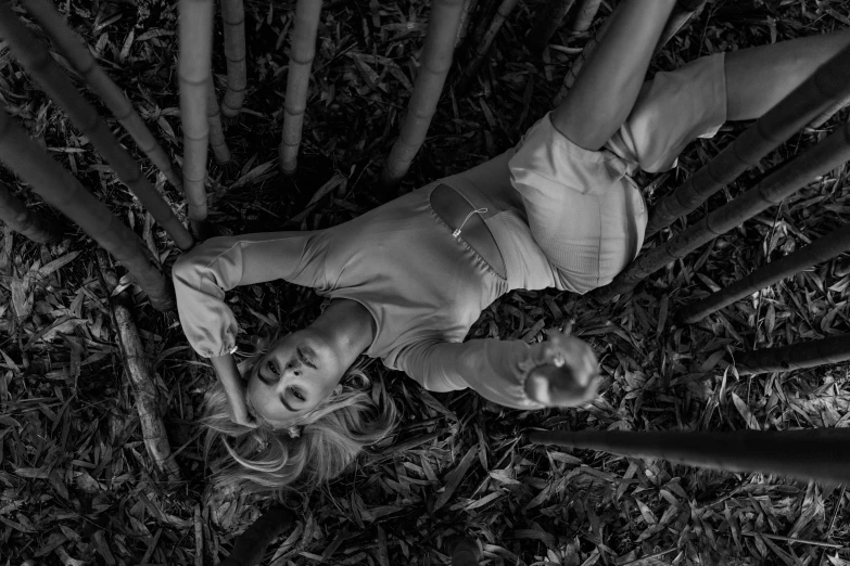 a couple of women laying on top of a lush green field, a black and white photo, trending on cgsociety, conceptual art, in a bamboo forest, portrait of kim petras, grim fashion model looking up, crashed in the ground