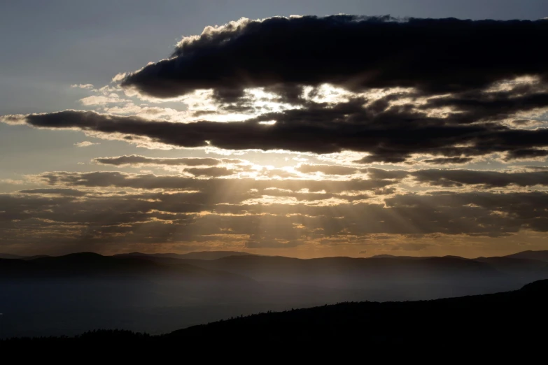 clouds and sun beams peeking through the smokey sky