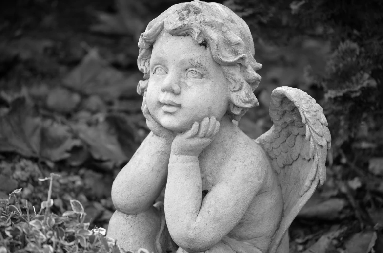 a black and white photo of a statue of an angel, a statue, by Marie Angel, concrete art, bashful expression, sitting in the garden, cherub, small stature