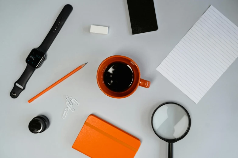 a table topped with a cup of coffee and a magnifying glass, trending on pexels, postminimalism, grey orange, educational supplies, bold black lines, looking towards camera