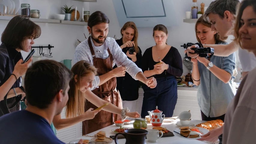 a group of people standing around a table with food, a portrait, by Emma Andijewska, pexels contest winner, pouring techniques, avatar image, dessert, cooking show