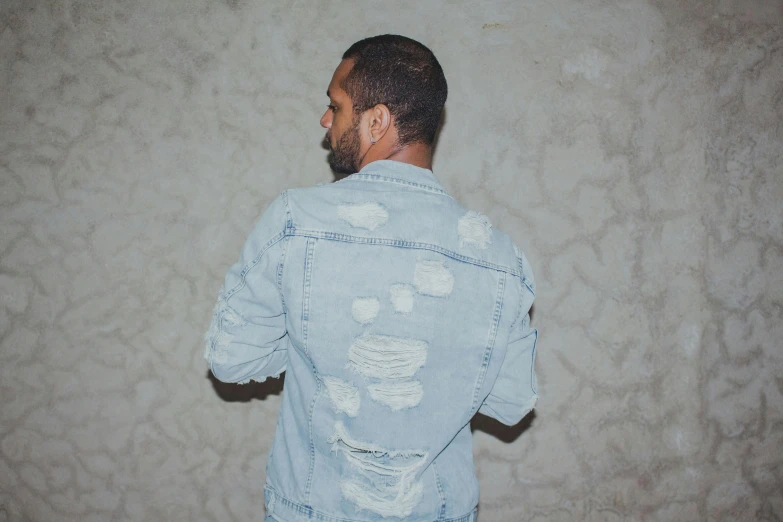 a man in ripped jeans looking back, side view