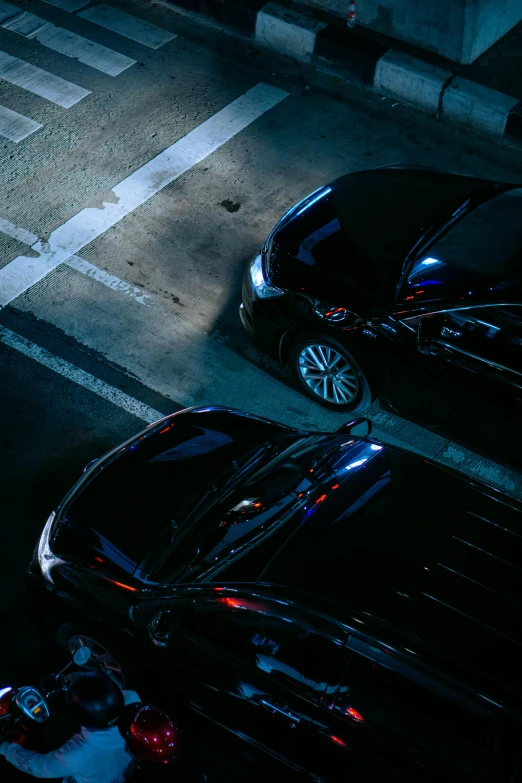 two cars in parking space next to each other at night