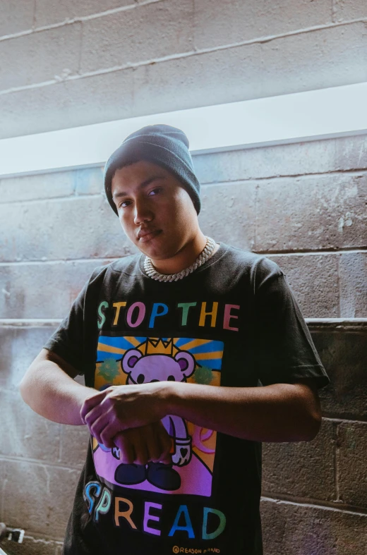 a man standing in front of a brick wall, an album cover, inspired by Eddie Mendoza, unsplash, graffiti, non binary model, wearing a stop sign on its head, teddy fresh, chris chan