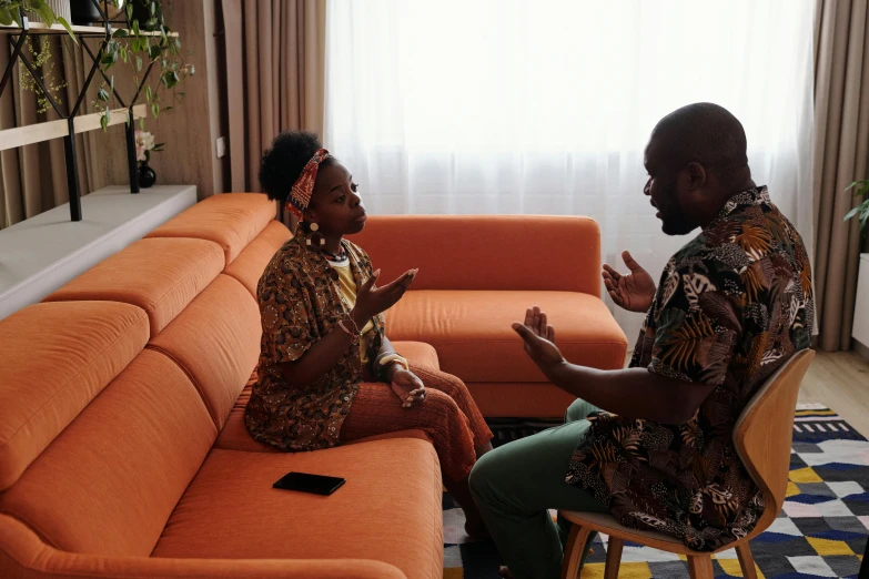 two people sitting in a living room next to couches