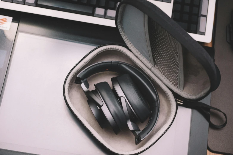 a laptop computer sitting on top of a desk next to a pair of headphones, hurufiyya, detailed product image, synthetic materials, tannoy, monochrome