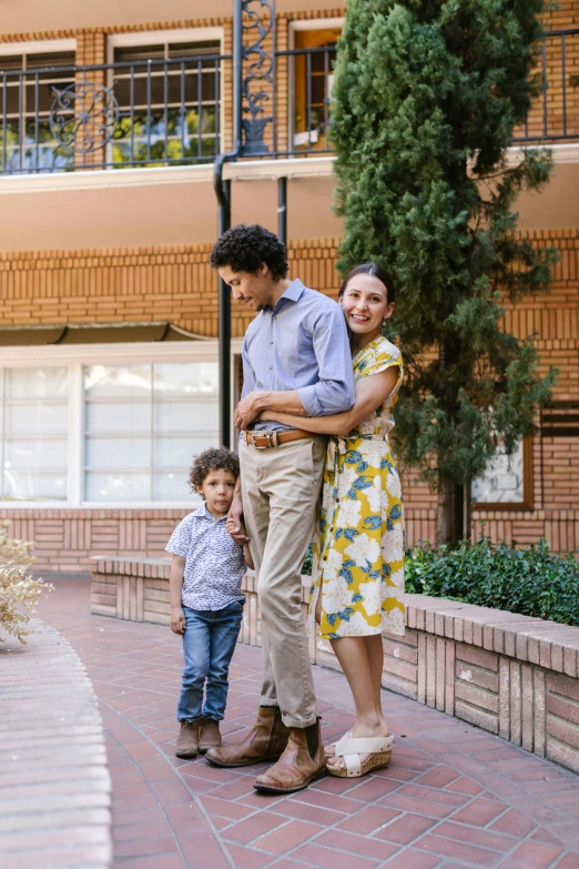 a man standing next to a woman and two children, unsplash, courtyard walkway, spanish, portrait image, promotional image