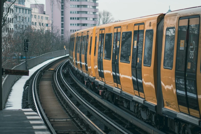 a train going down the tracks near some buildings