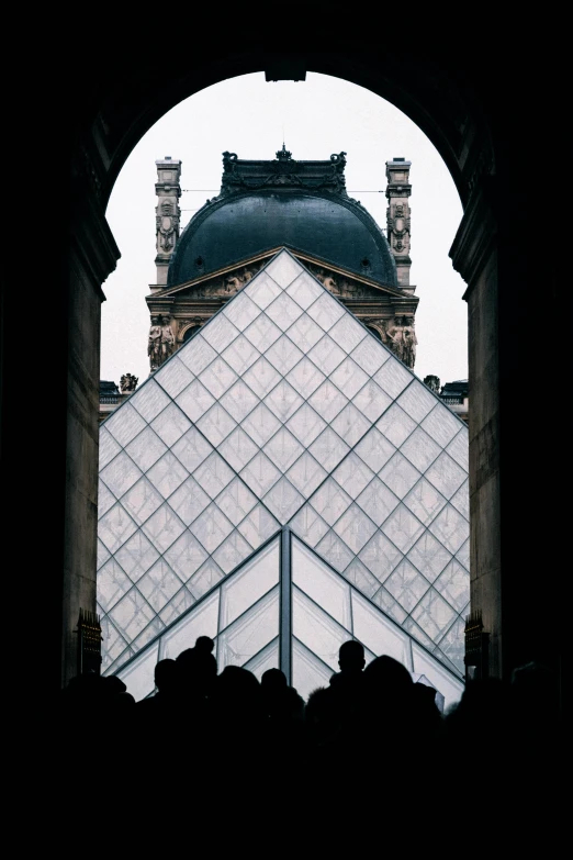 a group of people standing in front of a building, an album cover, inspired by Thomas Struth, trending on unsplash, louvre, triangles, view from inside, crowds