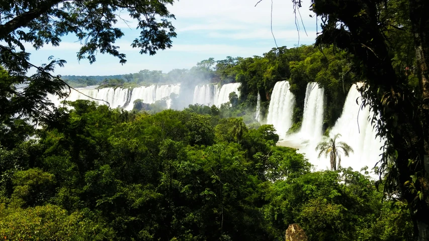 a waterfall surrounded by trees in the background