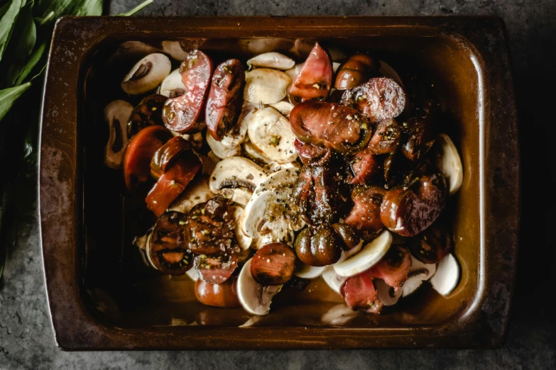 a pan filled with meat and vegetables on top of a table, a portrait, unsplash, chorizo sausage, “ iron bark, shaded, smoked layered