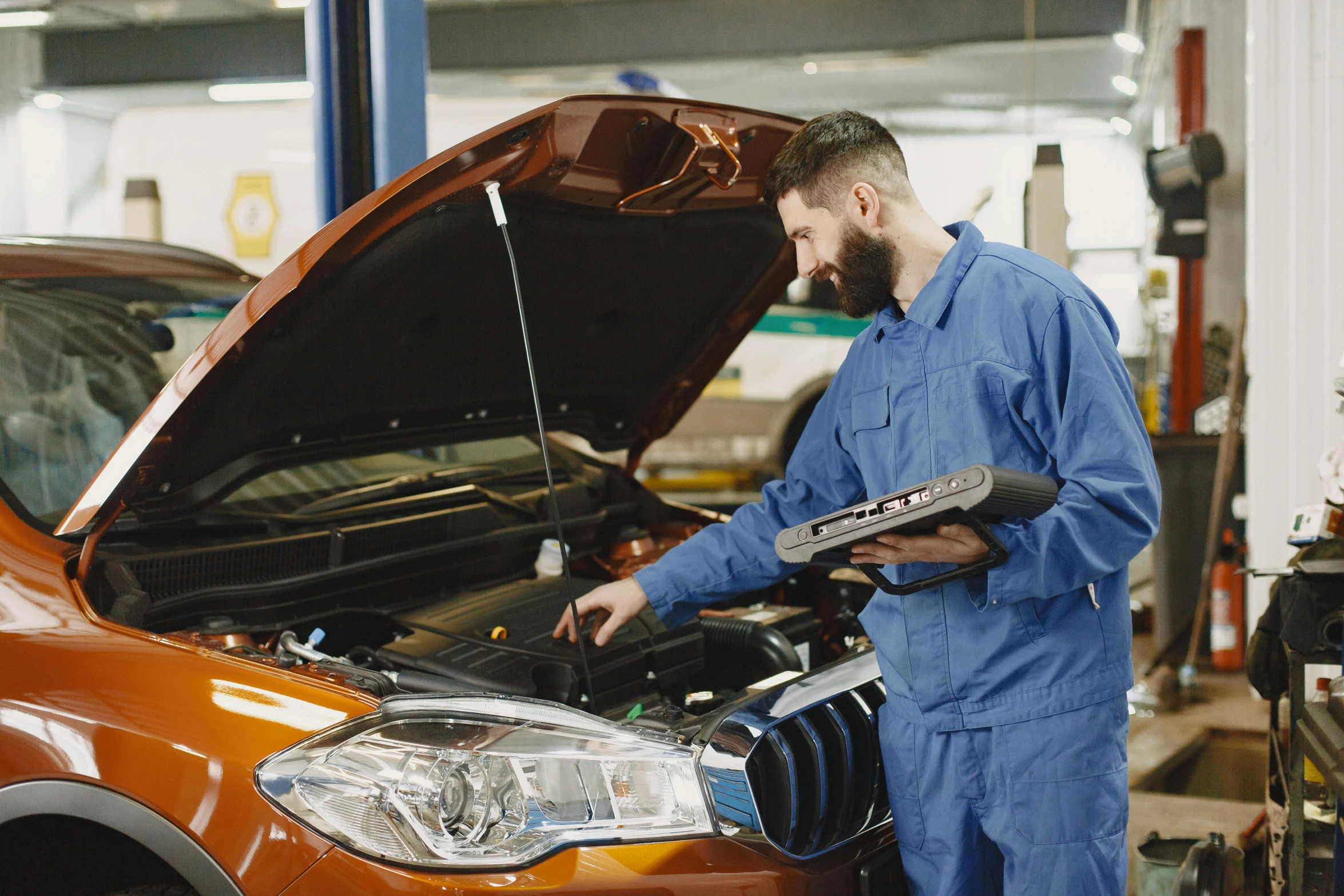 a man working on a car in a garage, a portrait, shutterstock, rococo mechanical and electronic, a brightly coloured, diagnostics, medium head to shoulder shot