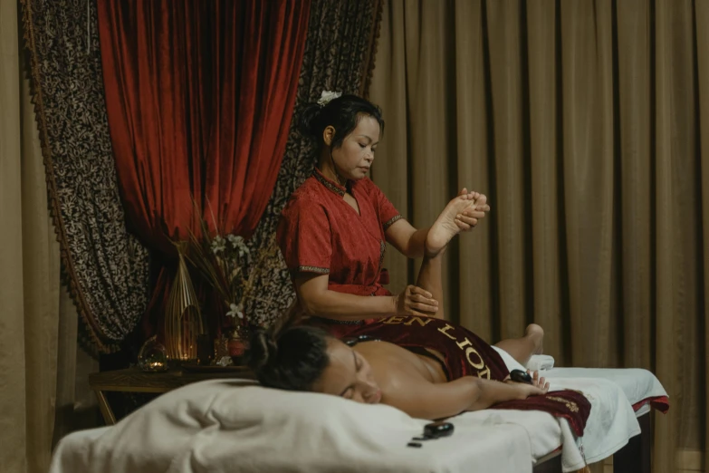 a woman getting a massage at a spa, pexels contest winner, wearing gilded red robes, south east asian with long, asian male, gif