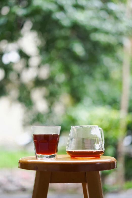 two glasses of tea sit on an old style table