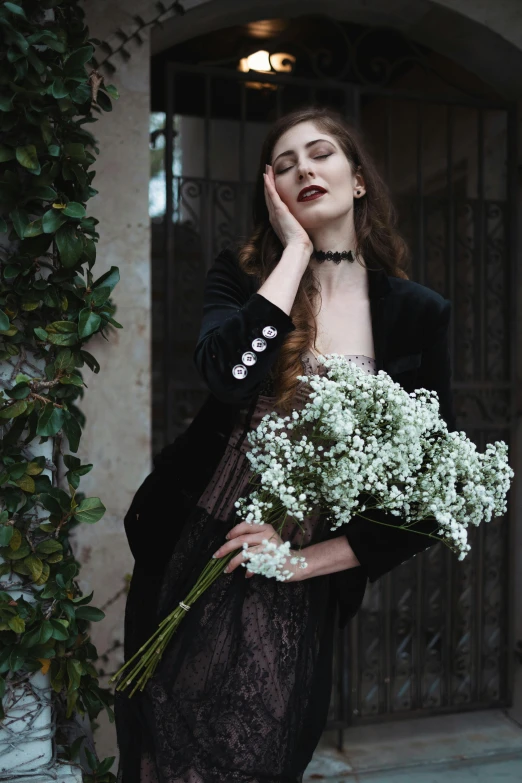 a woman in a black dress holding a bunch of flowers, inspired by Elsa Bleda, pexels contest winner, renaissance, gothic jacket, (12x) extremely pale white skin, gypsophila, non binary model