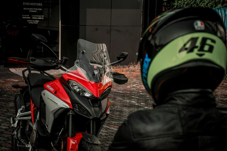 a man with a helmet on a red motorcycle