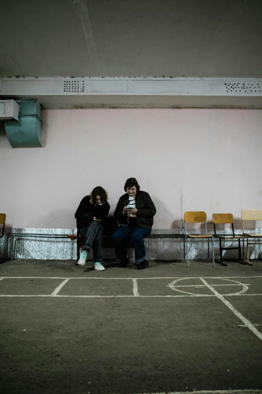 two people sitting on a bench in a parking lot, by Elsa Bleda, danube school, in a school classroom, war in ukraine, game ready, in school hallway