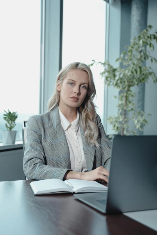 a woman sitting in front of a laptop computer, lawyer clothing, a girl with blonde hair, thumbnail, multiple stories