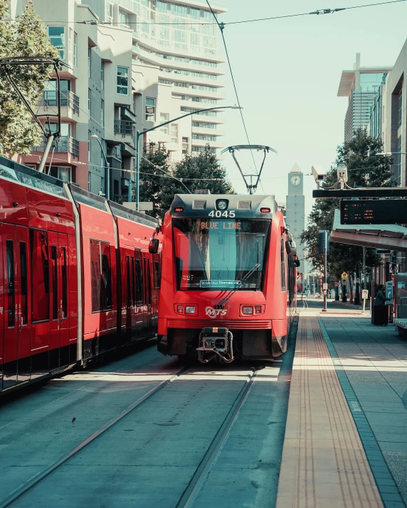 a couple of trains that are sitting on the tracks, unsplash contest winner, regionalism, city streetscape, bright red, lgbt, los angeles ca