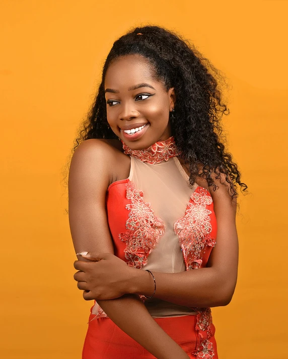 a woman in a red dress posing for a picture, by Chinwe Chukwuogo-Roy, pexels contest winner, orange halter top, smiling sweetly, promo image, high resolution product photo