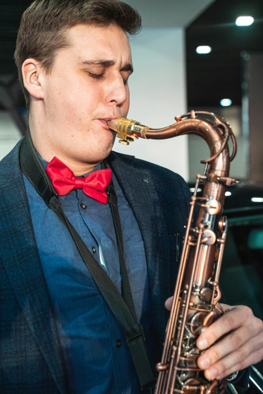 a man with a red bow tie playing a saxophone