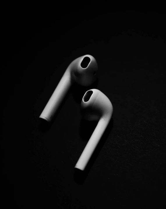a pair of airpods sitting on top of a table, inspired by Robert Mapplethorpe, unsplash, black background, pipe, thumbnail, sport