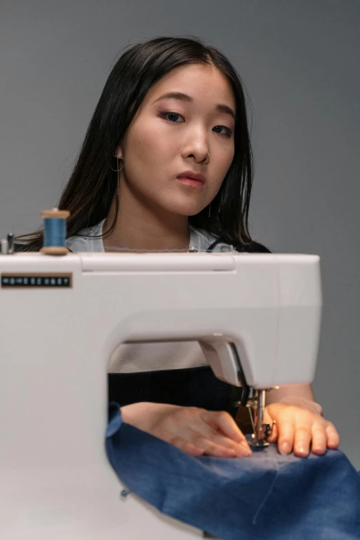 a young lady is using a sewing machine