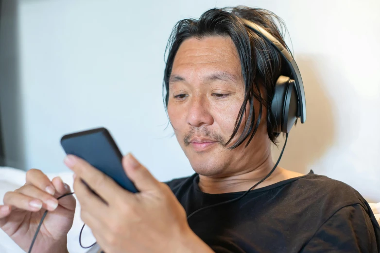 a man wearing headphones holding an mp3 player